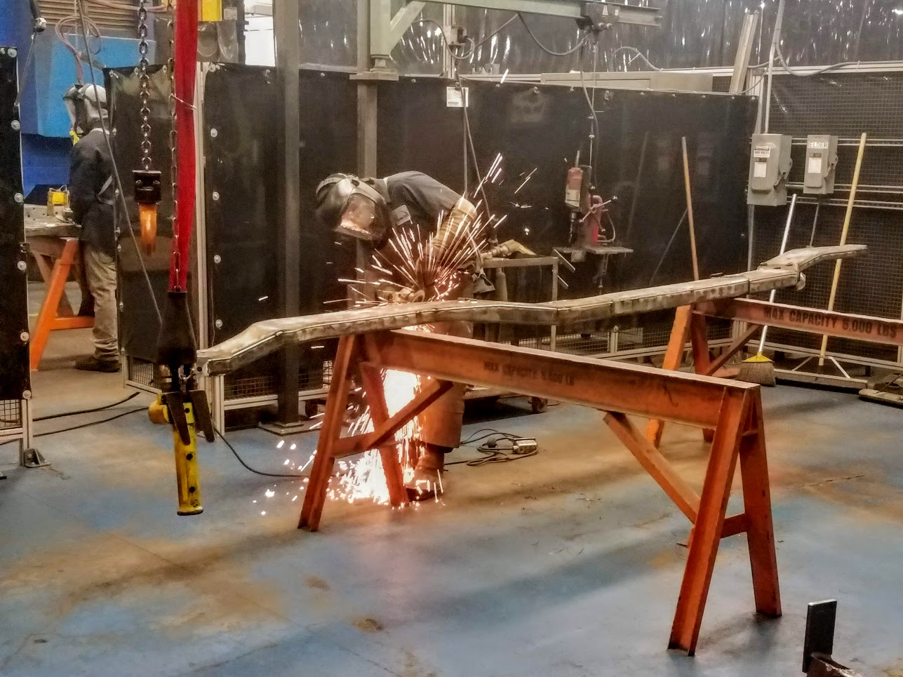 E&E Manufacturing employee cutting through metal frame.