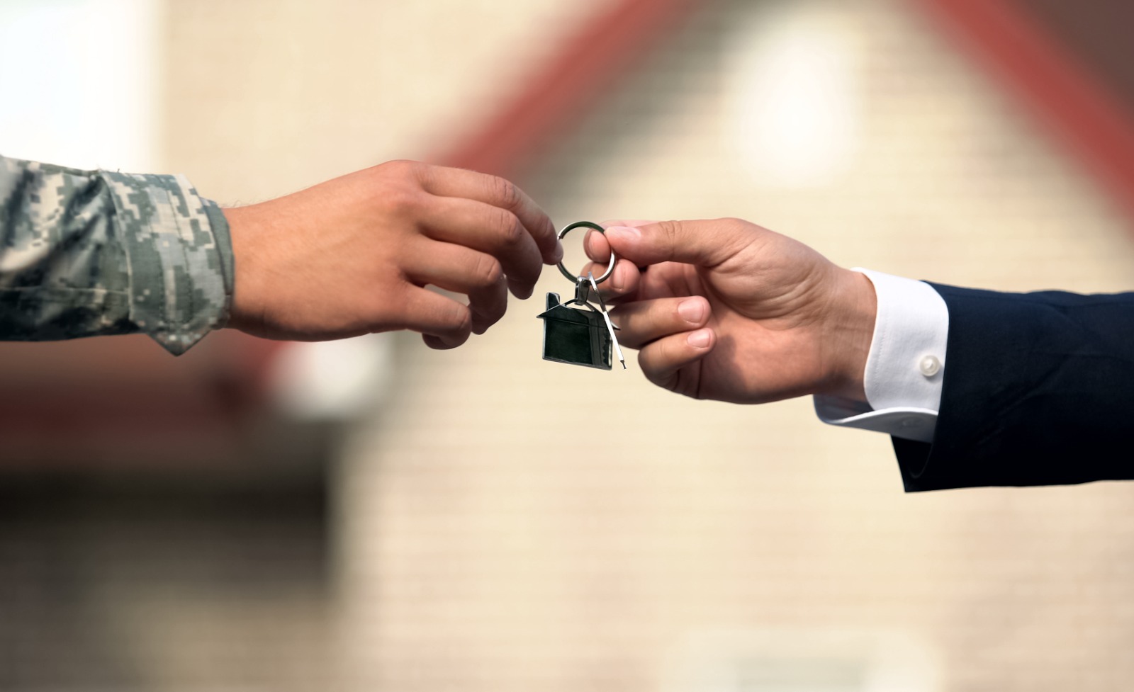 Two male hands exchanging house keys for the purchase of a new home