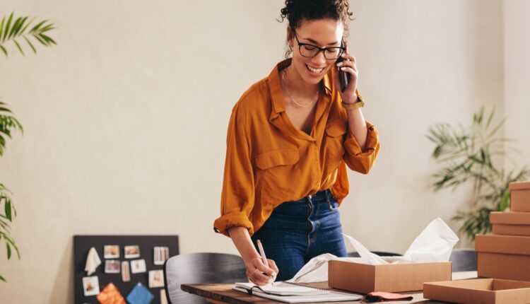 A woman smiling while talking on a cell phone