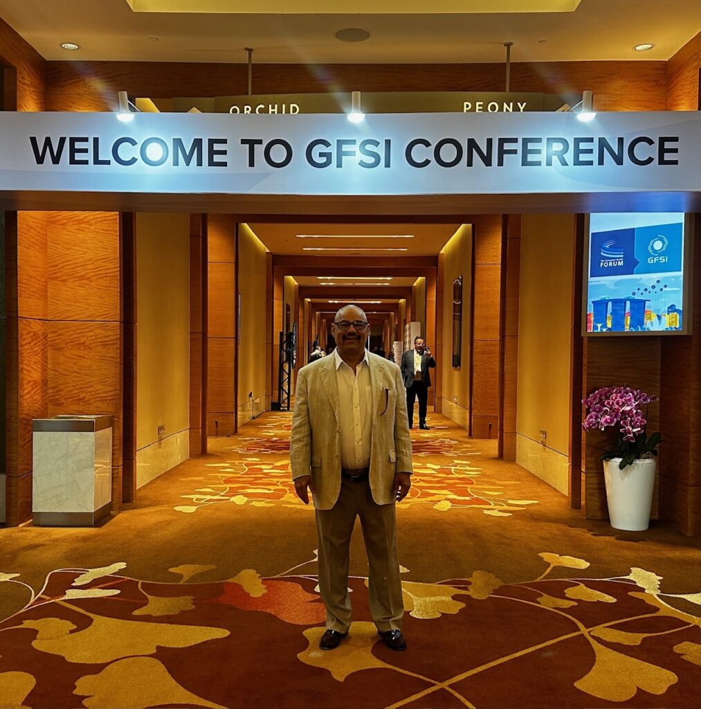 Linwood Rayford standing in the lobby with a Welcome to GFSI Conference sign behind him.
