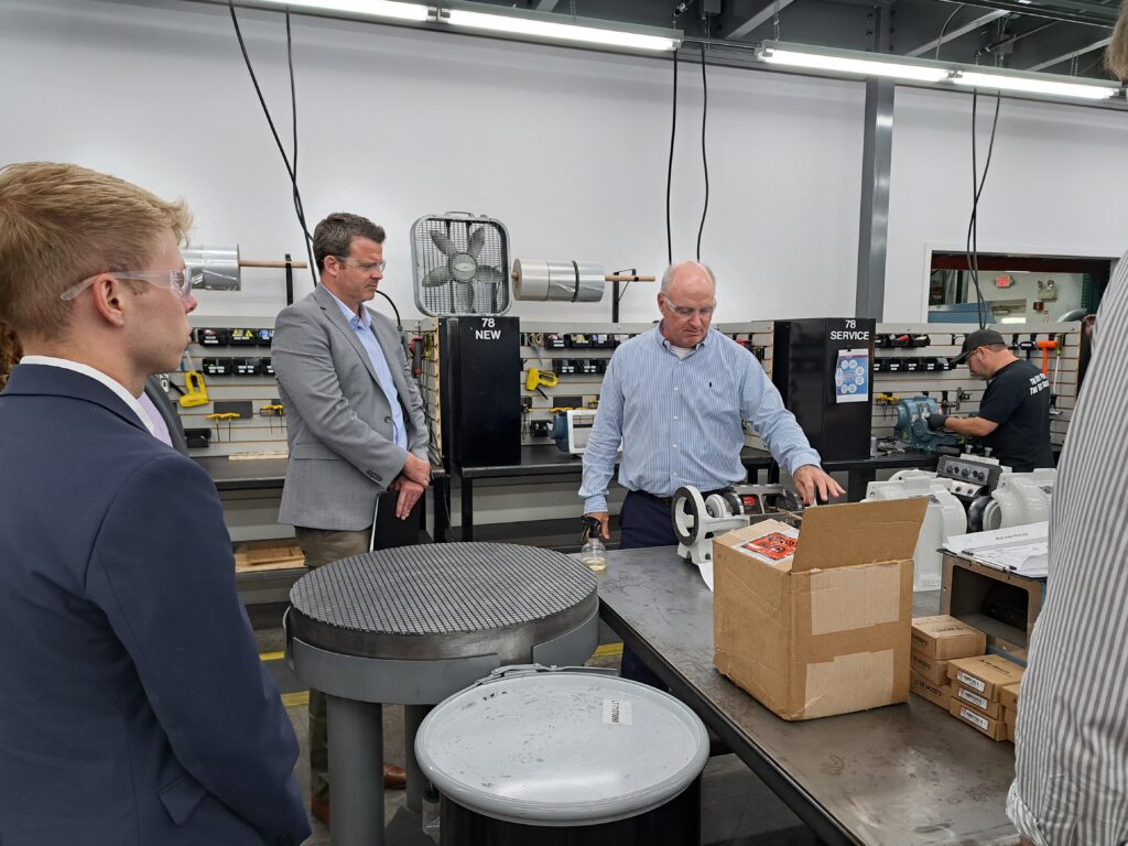 Advocacy staff watch as John Coates, chief operating officer of Precision Air Control, showcases a piece of equipment.