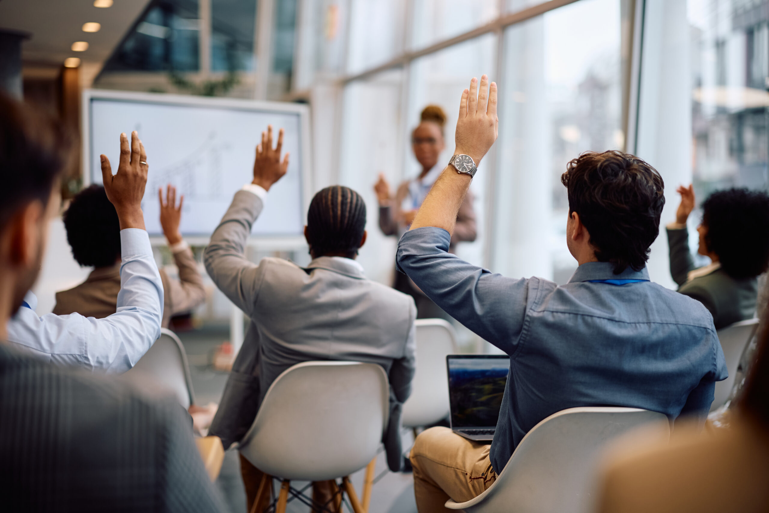 View of entrepreneurs asking questions from the audience while attending a business conference.