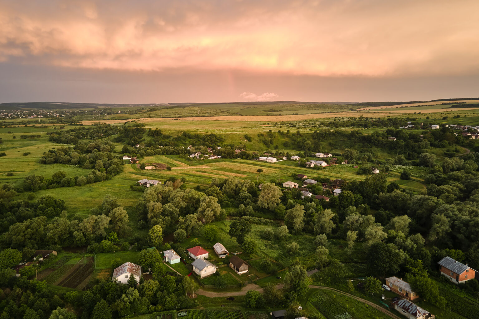 Aerial view of residential houses in a suburban rural area at sunset.