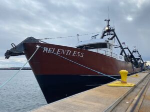 A boat named Relentless stationed on a dock.