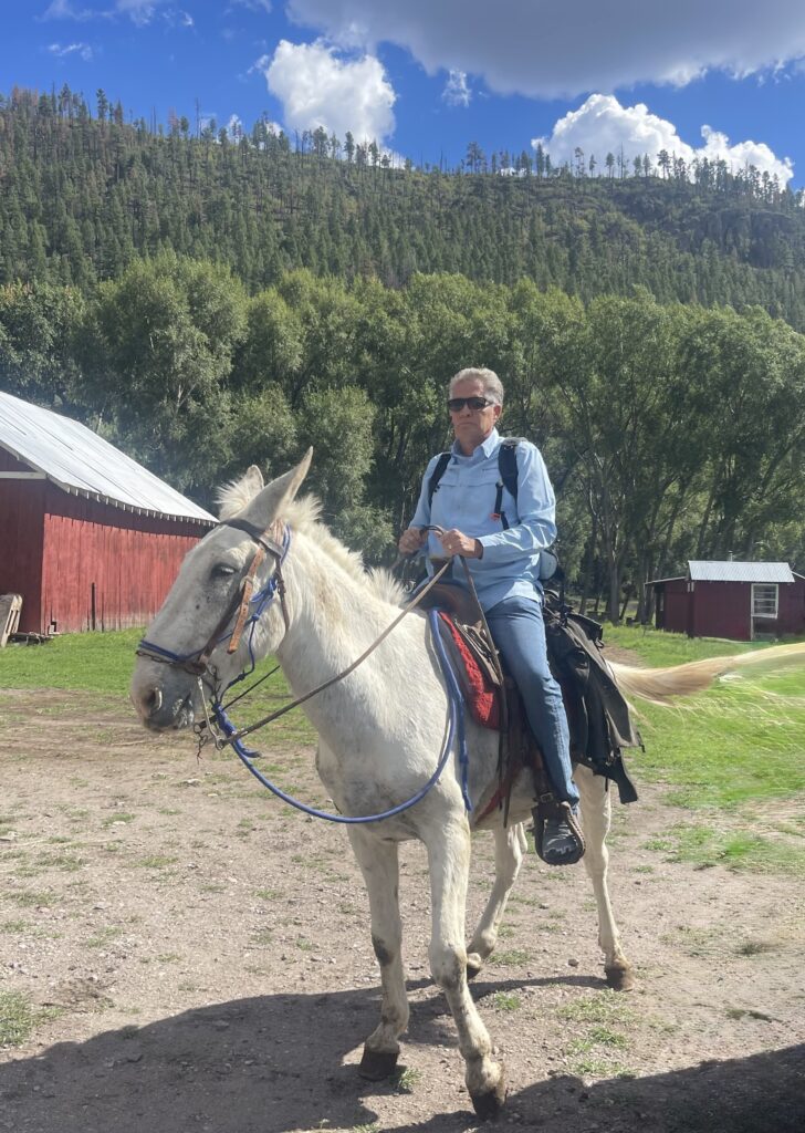 Bill Gravell riding Stinking the mule on a ranch in New Mexico